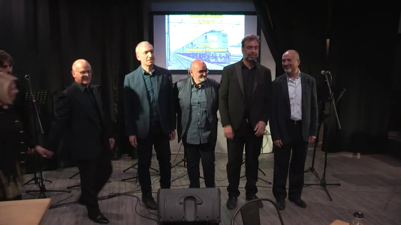 Il finale de Il Pantografo con gli interpreti e lo schermo alle loro spalle
