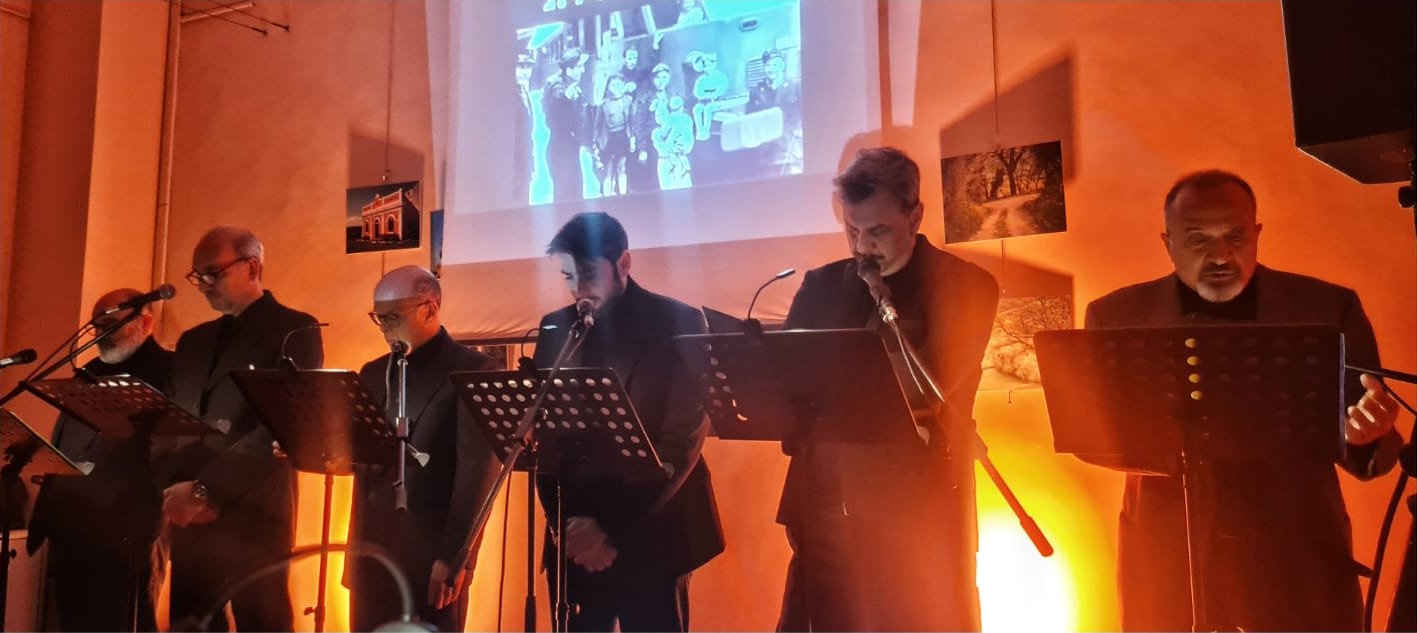 Un momento de Il Pantografo con gli interpreti ai leggii, luci di scena e proiezione